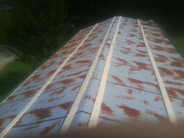 Rusted metal roof panels with new wood purlins before replacement — Storm Damage Roof Repair in Waldron by Roofing Brothers